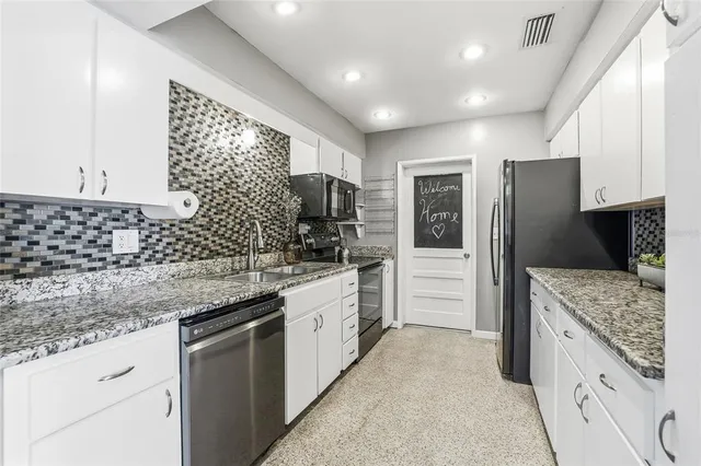 a kitchen with stainless steel appliances granite countertop a sink and cabinets