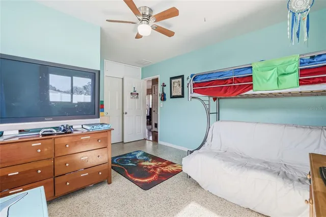 a bedroom with furniture and a chandelier fan