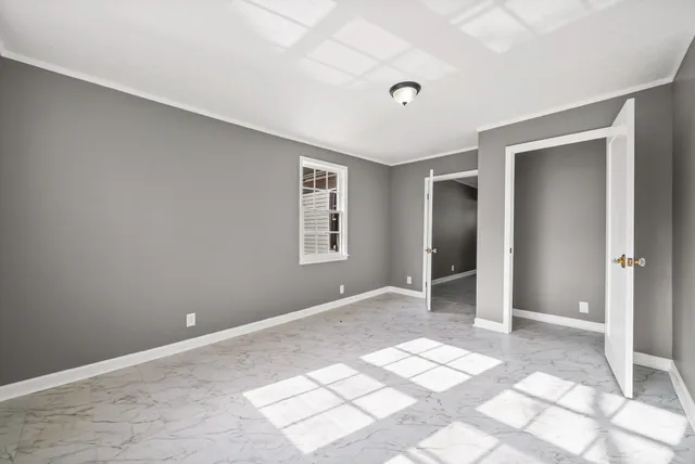 an empty room with closet and a window