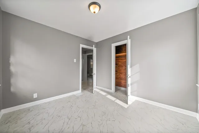 a view of empty room with wooden floor and window