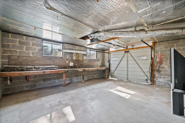 a view of a white house with large windows next to a yard