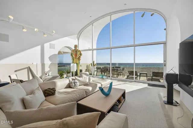 a spacious bedroom with a bed a couch and a painting on the wall