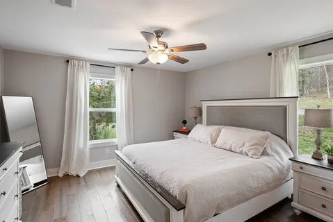 a bedroom with a bed a window and a flat screen television
