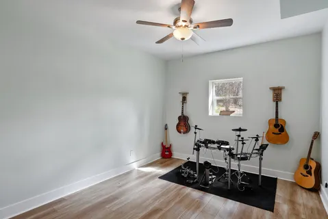 a view of a hallway with wooden floor and a flat screen tv