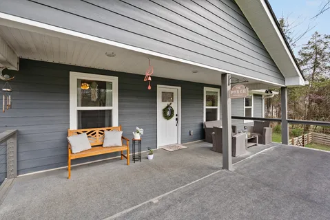 a backyard of a house with sofas and wooden fence