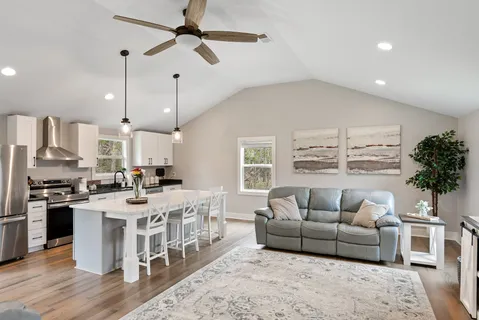 a living room with furniture and a dining table with kitchen view