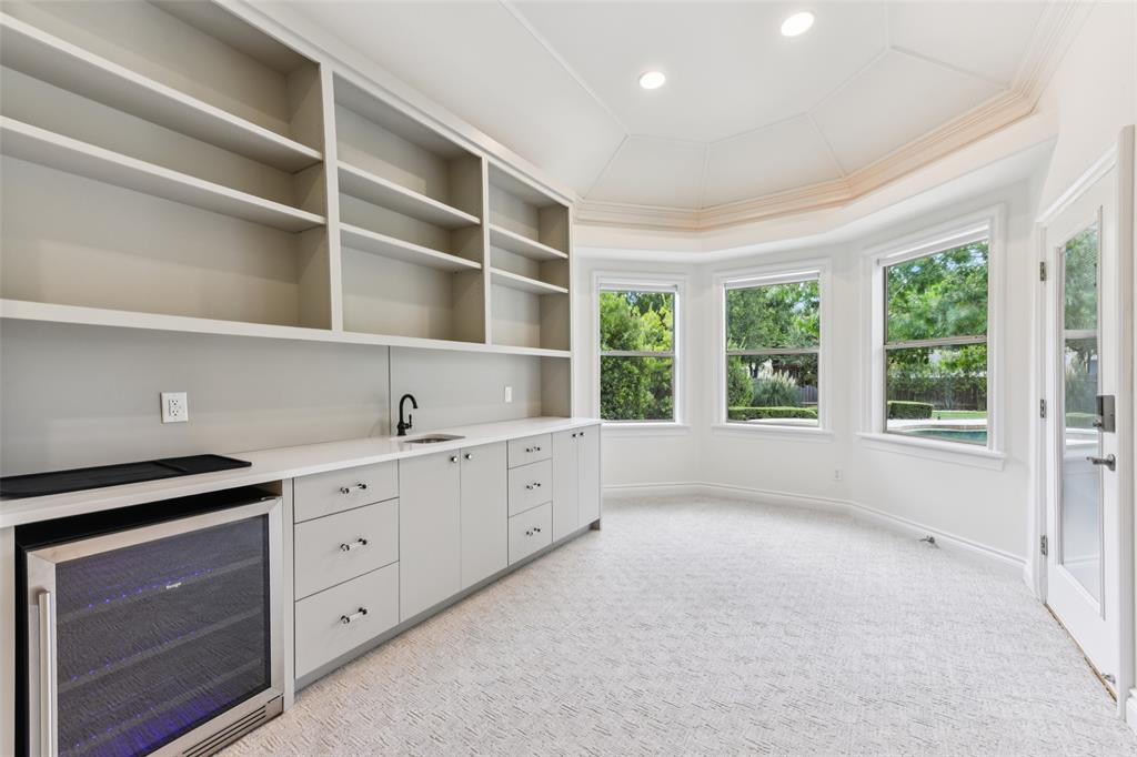 2203 Court Del Rey Round Rock, TX 78681 - Photo 12 of 35 Bar with beverage cooler, light colored carpet, and open shelves
