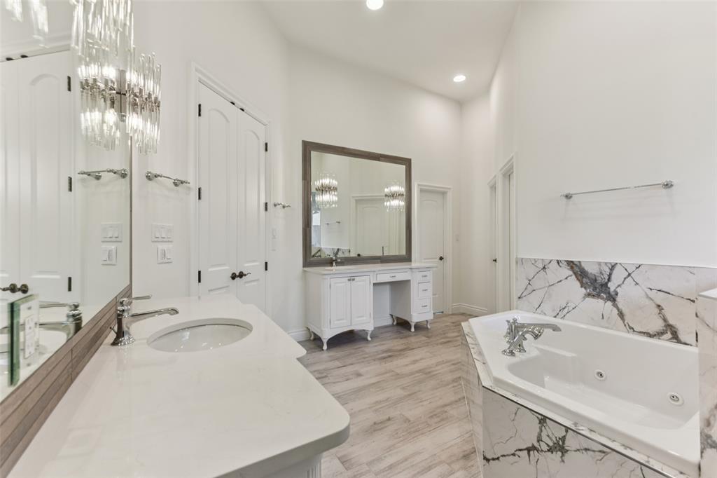 2203 Court Del Rey Round Rock, TX 78681 - Photo 13 of 35 Full bath featuring two vanities, a whirlpool tub, recessed lighting, and a chandelier