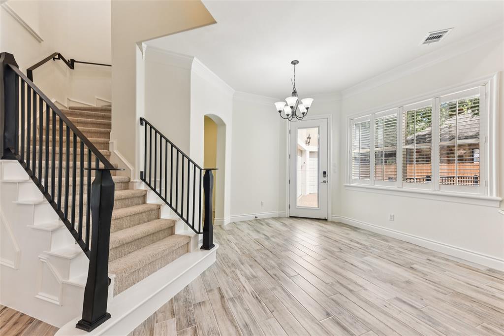 2203 Court Del Rey Round Rock, TX 78681 - Photo 27 of 35 Entrance foyer featuring crown molding, stairway, light wood-type flooring, a chandelier, and arched walkways