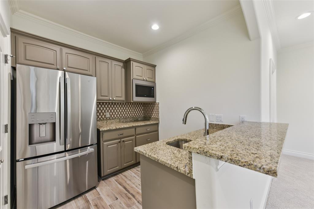 2203 Court Del Rey Round Rock, TX 78681 - Photo 29 of 35 Kitchen featuring stainless steel appliances, light stone countertops, ornamental molding, backsplash, and gray cabinets