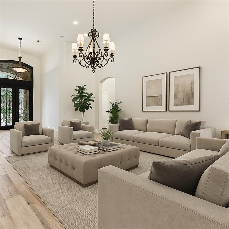 2203 Court Del Rey Round Rock, TX 78681 - Photo 5 of 35 Living area featuring arched walkways, a high ceiling, hardwood / wood-style flooring, and a chandelier