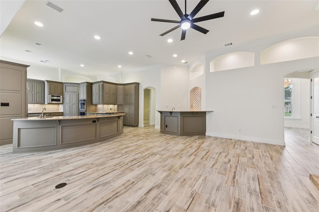 2203 Court Del Rey Round Rock, TX 78681 - Photo 35 of 35 Kitchen featuring arched walkways, gray cabinetry, light wood-style floors, tasteful backsplash, and open floor plan