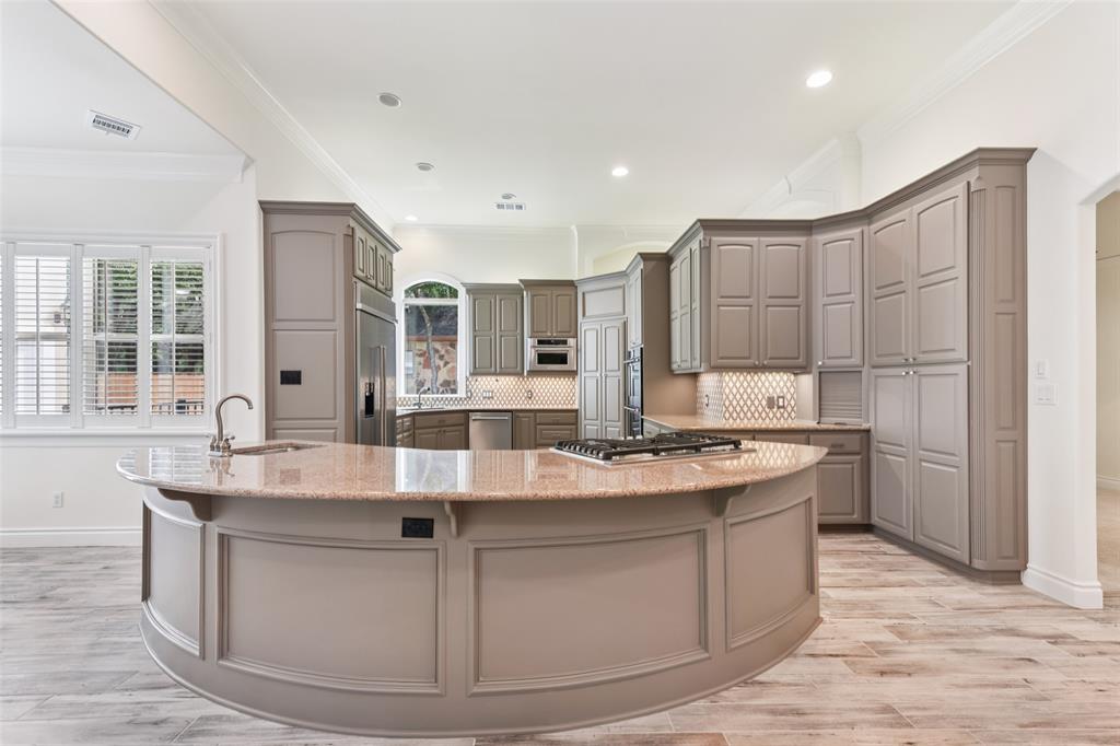 2203 Court Del Rey Round Rock, TX 78681 - Photo 7 of 35 Kitchen with gray cabinetry, tasteful backsplash, crown molding, light wood-type flooring, and light stone countertops