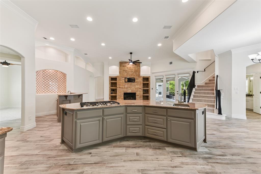2203 Court Del Rey Round Rock, TX 78681 - Photo 8 of 35 Kitchen featuring gray cabinetry, a large fireplace, ceiling fan, arched walkways, and crown molding