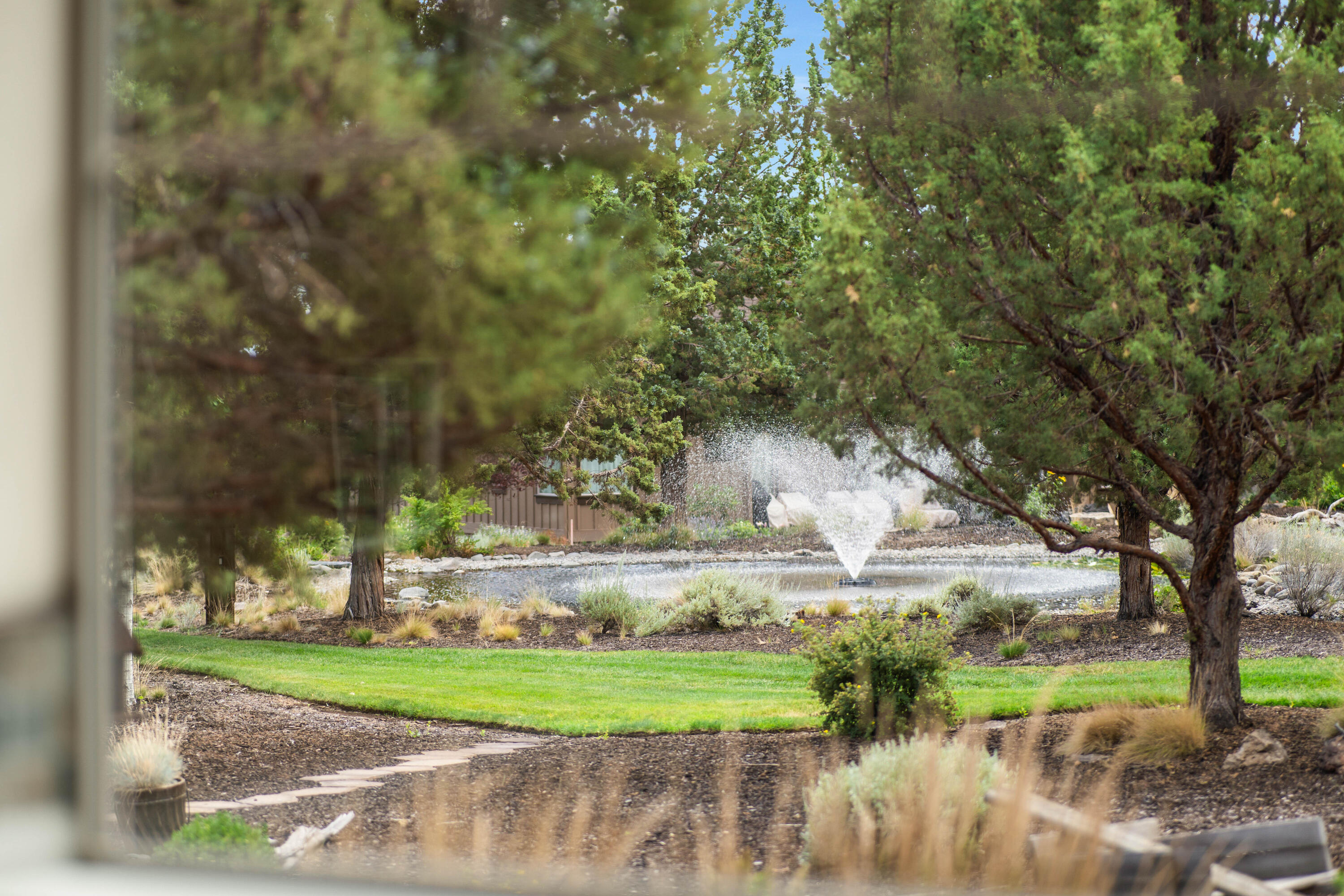 205 Vista Rim Drive Redmond, OR 97756 - Photo 28 of 85 a view of a fountain in a yard with large trees