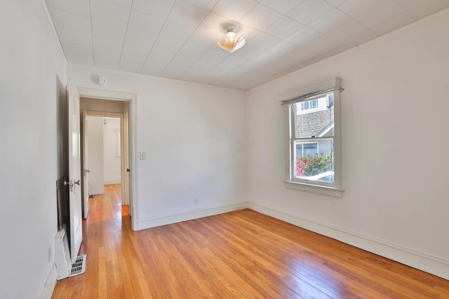494 Lewis Avenue San Leandro, CA 94577 - Photo 12 of 19 an empty room with wooden floor and windows