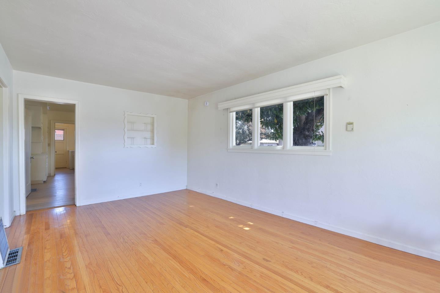494 Lewis Avenue San Leandro, CA 94577 - Photo 6 of 19 a view of an empty room with wooden floor and a window