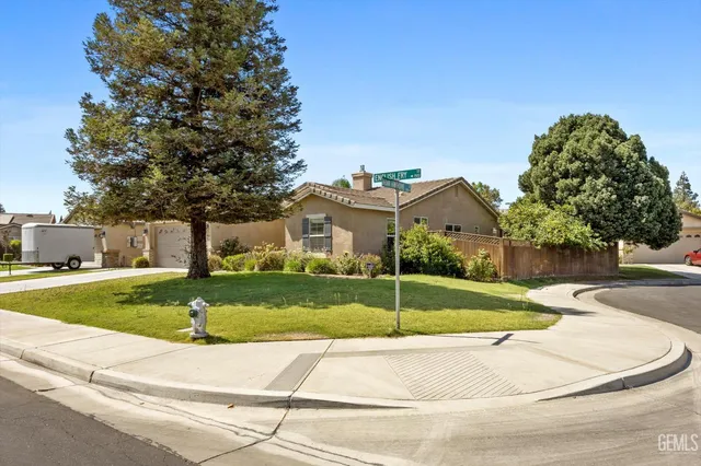 a white house with a yard and a large tree