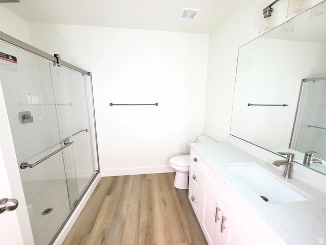 683 Kings Landing Tooele, UT 84074 - Photo 26 of 39 Modern bathroom featuring a single vanity with integrated sink, brushed nickel faucet, large frameless mirror, and a three-light vanity fixture