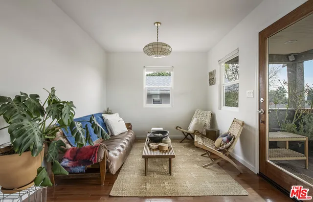 a living room with furniture potted plant and a window