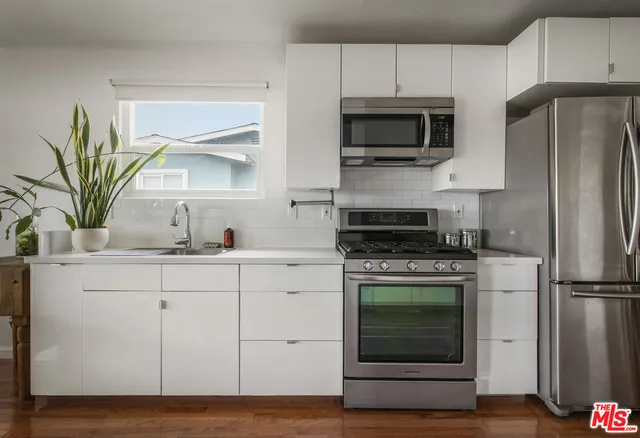 a dining room with furniture potted plants and wooden floor