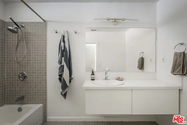 a bathroom with a bathtub a sink a vanity and a shower