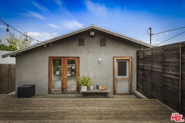 a view of a patio with table and chairs potted plants with wooden floor and fence