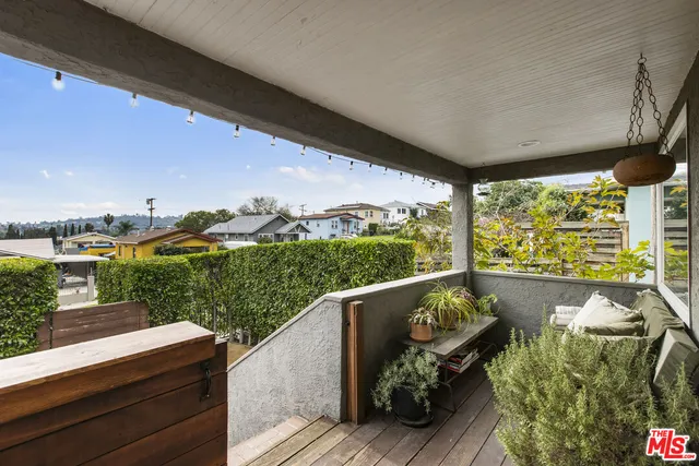 a balcony with wooden floor and outdoor seating
