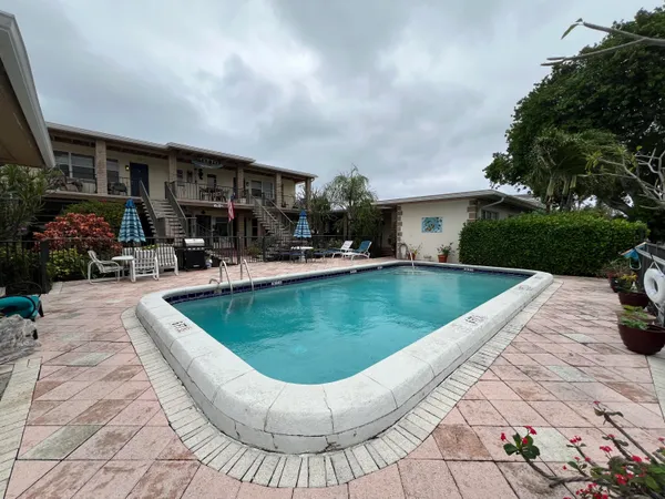 a view of swimming pool with outdoor seating and plants