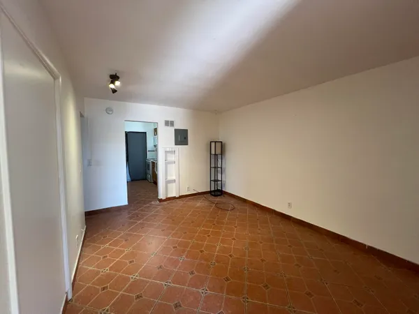 a view of an empty room with closet and windows