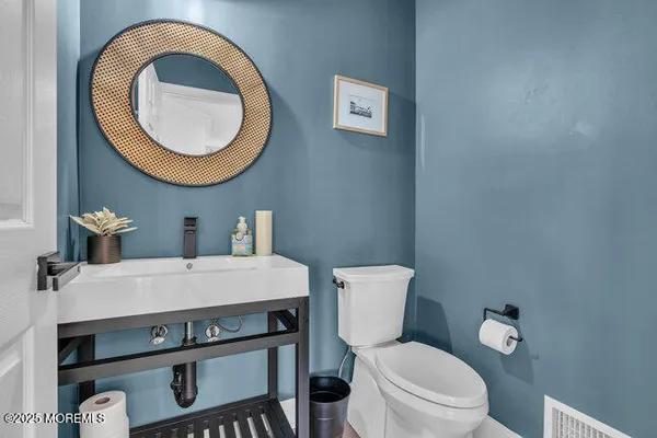 a bathroom with a toilet a sink and a mirror