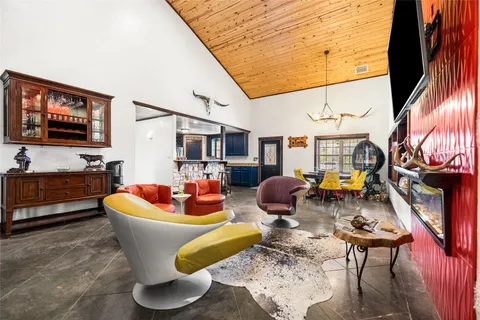 a living room with patio furniture and a flat screen tv