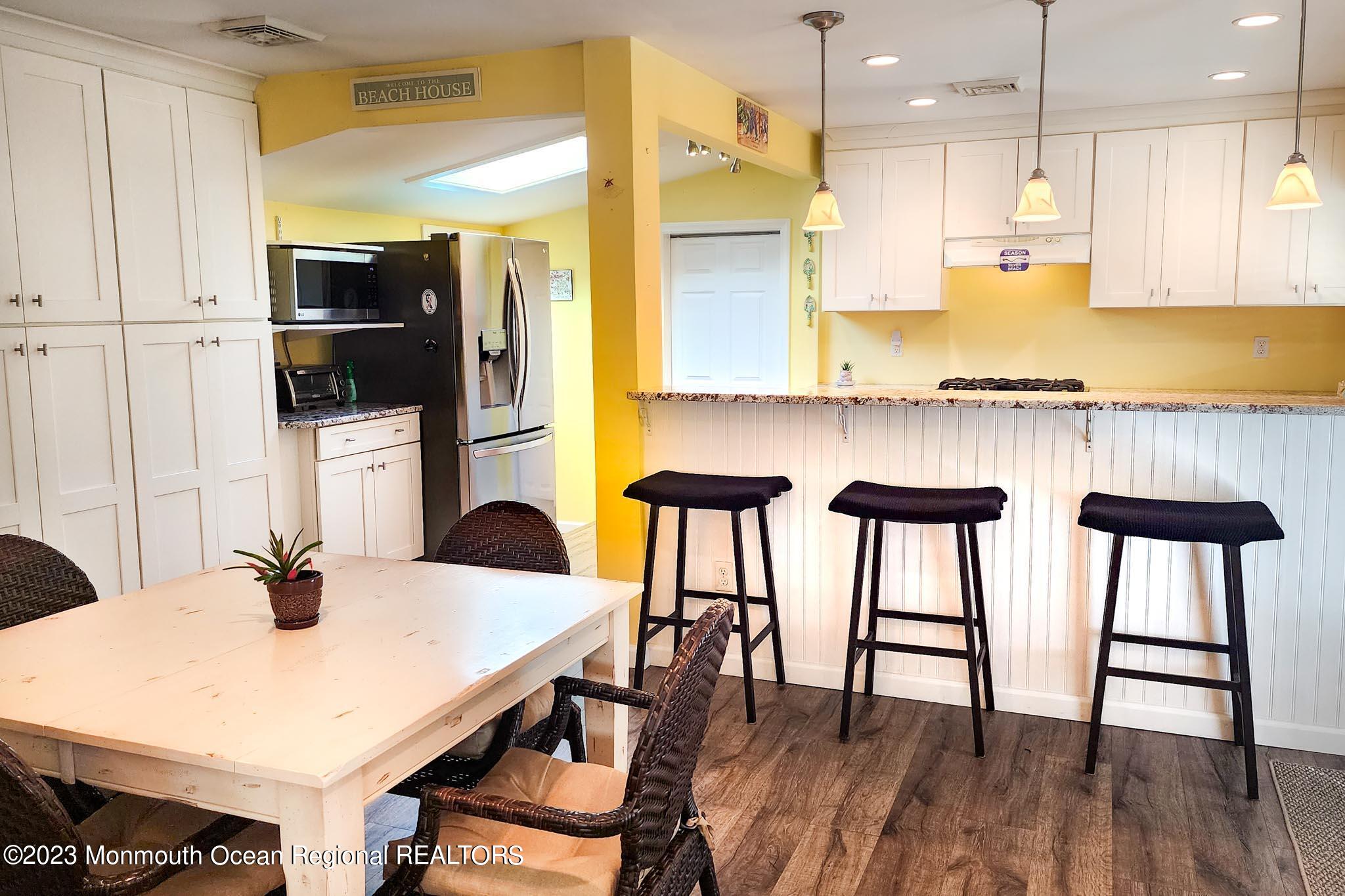 54 Silver Beach Road Lavallette, NJ 08735 - Photo 20 of 49 a kitchen with stainless steel appliances granite countertop a table chairs and a refrigerator