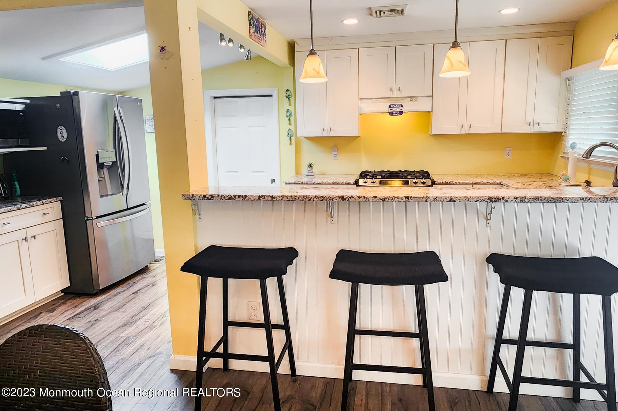 54 Silver Beach Road Lavallette, NJ 08735 - Photo 25 of 49 a kitchen with a table chairs in it and wooden floors
