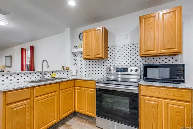 a kitchen with stainless steel appliances granite countertop a sink stove and cabinets