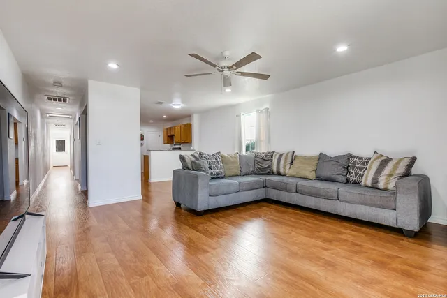 a living room with furniture and a wooden floor