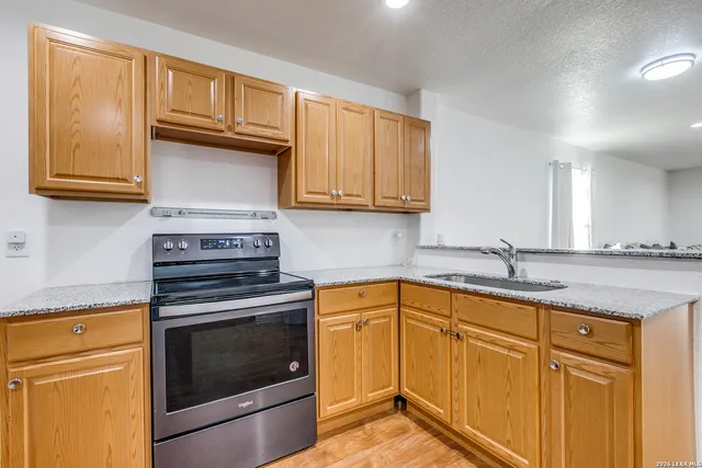 a kitchen with granite countertop cabinets stainless steel appliances and a sink