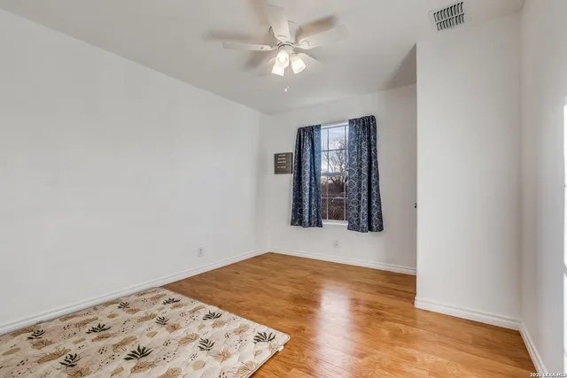 an empty room with a window and ceiling fan