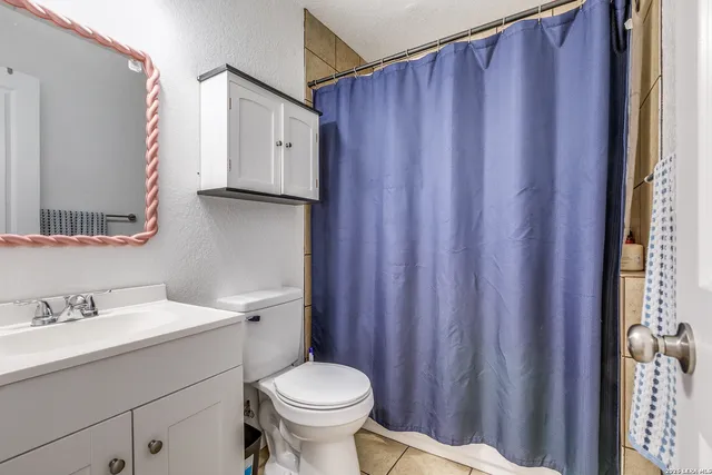 a bathroom with a sink a toilet and a mirror