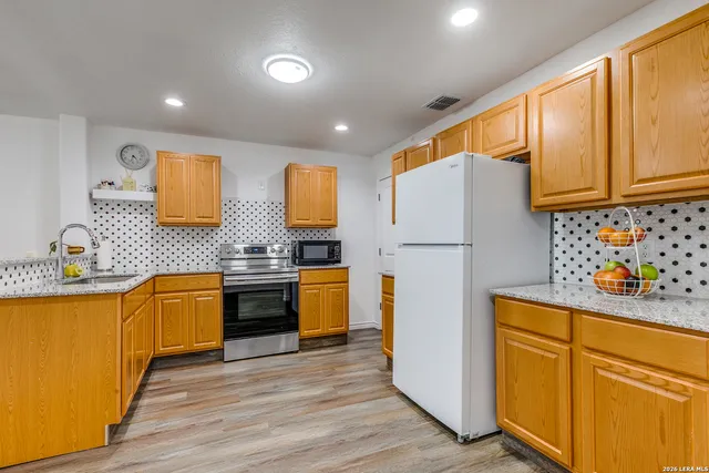 a kitchen with stainless steel appliances sink refrigerator and microwave