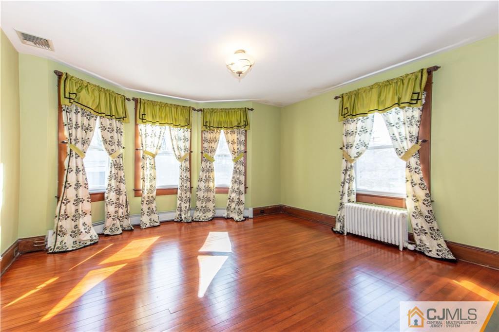 624 Ridge Road Monmouth Junction, NJ 08852 - Photo 6 of 15 a view of an empty room with wooden floor and a window