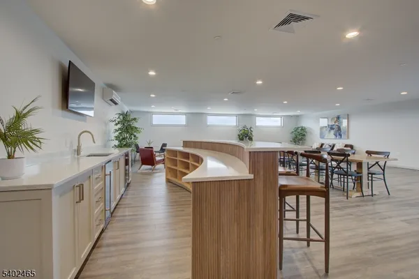 a kitchen with stainless steel appliances kitchen island granite countertop a table chairs in it and wooden floors