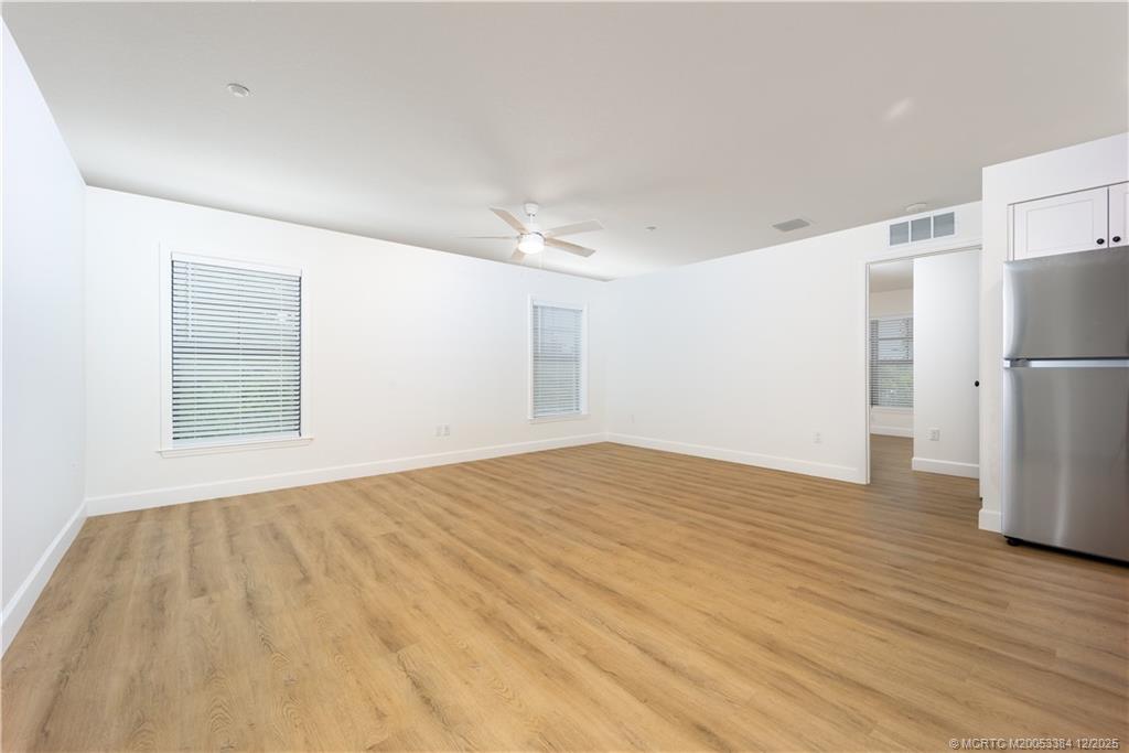 3375 Southwest Mapp Road, Unit 204 Palm City, FL 34990 - Photo 4 of 17 a view of an empty room with a kitchen and a refrigerator