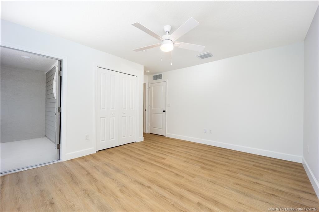 3375 Southwest Mapp Road, Unit 204 Palm City, FL 34990 - Photo 8 of 17 an empty room with wooden floor and fan
