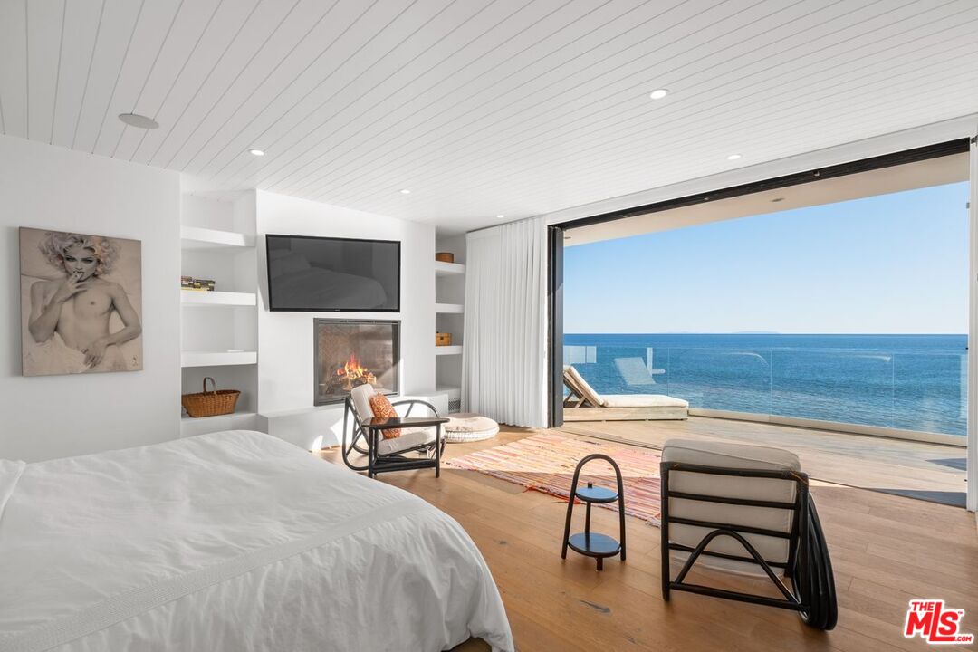 27212 Escondido Beach Road Malibu, CA 90265 - Photo 16 of 34 a bedroom with furniture and a fireplace