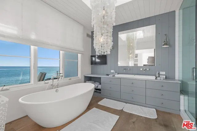 a spacious bathroom with a double vanity sink large mirror and a bathtub
