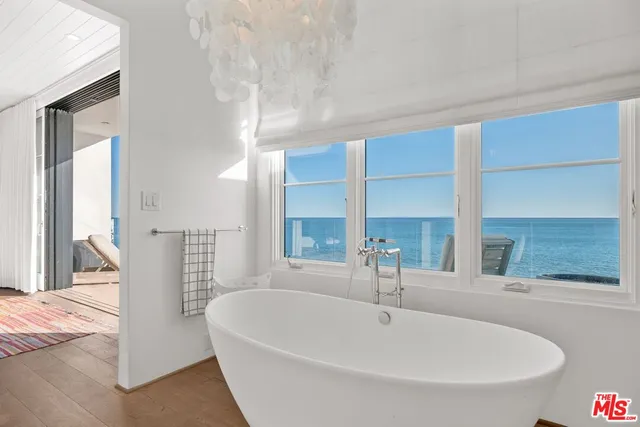 a white bath tub sitting in a bathroom next to a window