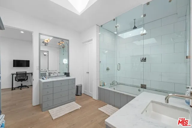 a spacious bathroom with a tub sink shower and mirror
