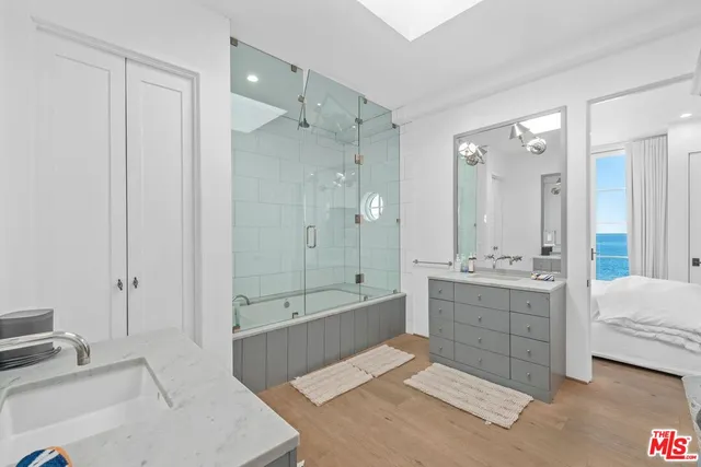 a spacious bathroom with a tub sink shower and mirror