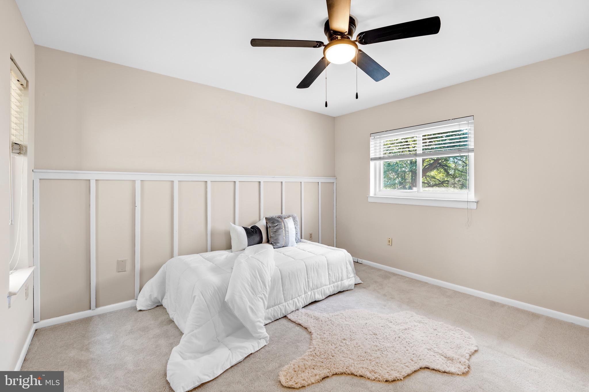 7512 Rolling Road Springfield, VA 22153 - Photo 21 of 32 a bedroom with a large bed and a chandelier fan